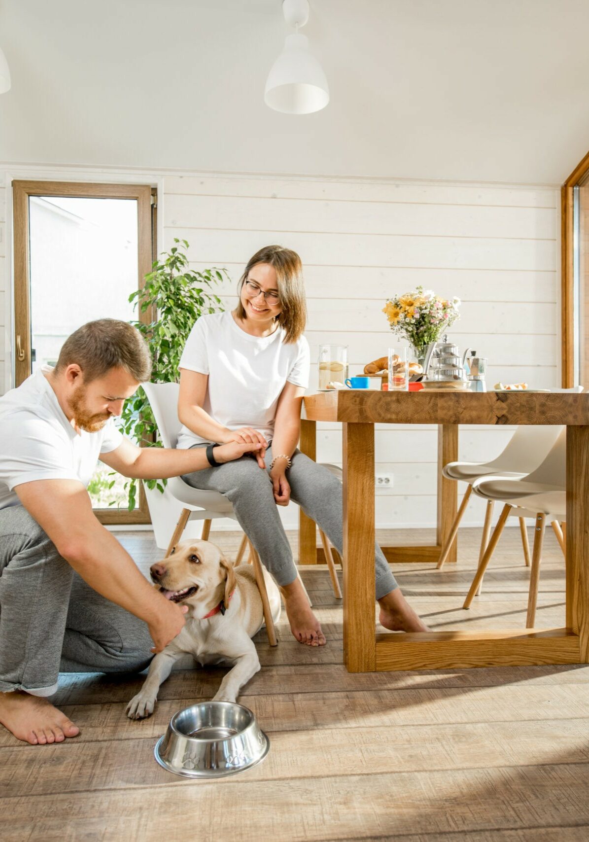 Happy couple with dog at home | About Floors N' More